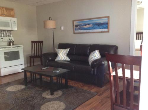 a living room with a black couch and a table at Strictly Moose Luxury Vacation Suites in Gorham