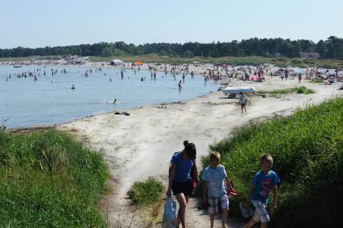 a group of people walking on a beach at Hotel Balka Strand in Neksø