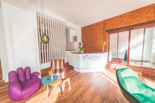 a living room with a couch and a chair at Hotel via City Leipzig Mitte in Leipzig