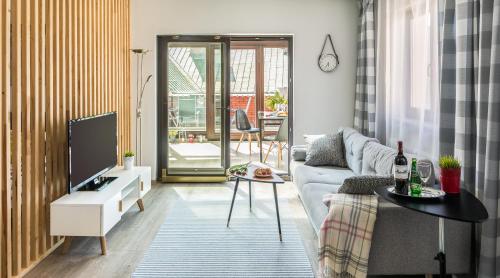 a living room with a couch and a tv at 7 Koron - Exclusive Apartments in Kraków