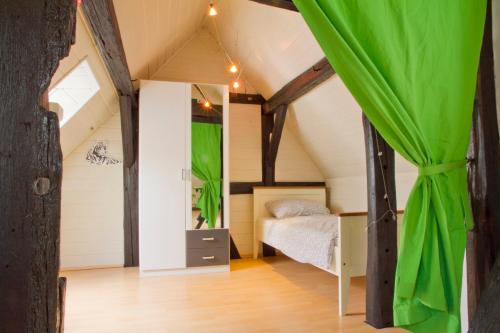 1 dormitorio en un ático con 1 cama y cortina verde en Ferienwohnung Fritz Walter, en Kreuzwertheim