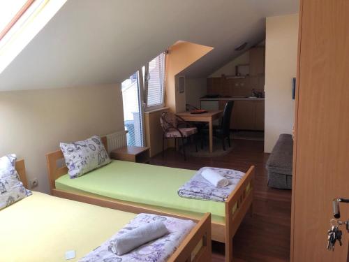 una piccola camera con due letti e una cucina di Apartmani Jovanovic a Ivanjica