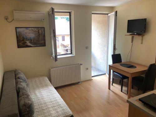 un soggiorno con un divano e un tavolo di Apartmani Jovanovic a Ivanjica