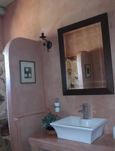 un bagno con lavandino e specchio di *Villa Pap-Live the Greek hospitality in a village* a Néa Sampsoús