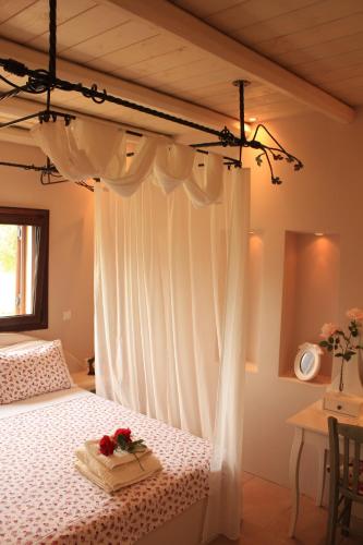 una camera da letto con un letto a baldacchino bianco decorato con fiori di *Villa Pap-Live the Greek hospitality in a village* a Néa Sampsoús