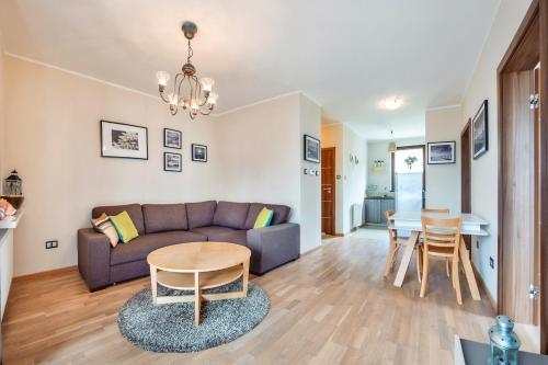 a living room with a couch and a table at Apartamenty Sun & Snow Rezydencja Park II in Mielno