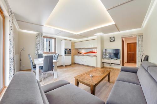 a living room with a couch and a table at Rezydencja Park, Sun & Snow in Mielno