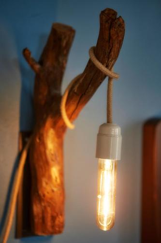 a light hanging from a piece of drift wood with a string at Earino in Kato Asites