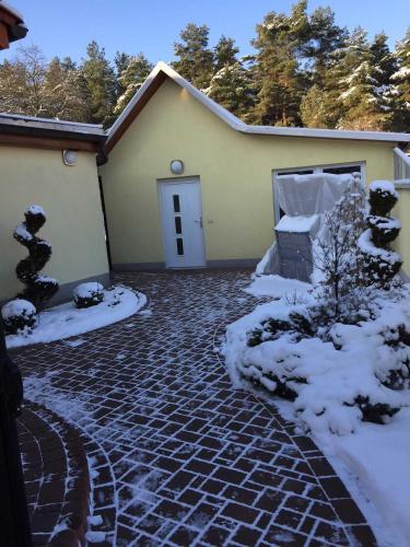 a house with a brick driveway in the snow at Ferienhaus Zschieck in Torno