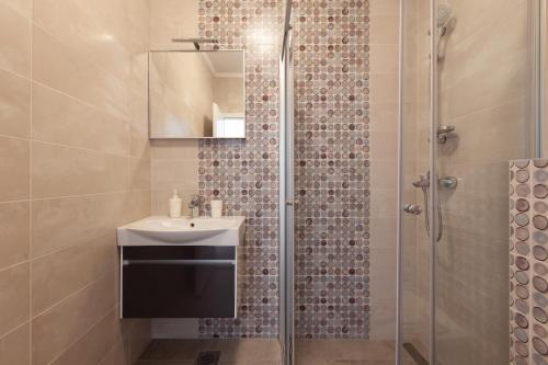 a bathroom with a sink and a shower at Apartments Coast 27 in Podgora