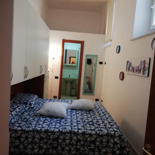 a bedroom with a bed with two pillows and a mirror at Stanzetta del Cavaliere in Atrani
