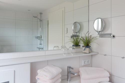 La salle de bains est pourvue d'un lavabo et d'un miroir. dans l'établissement Strandhaus Christiansen, à Cuxhaven