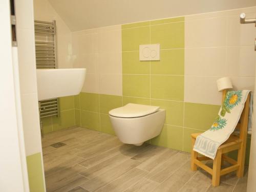 łazienka z toaletą, umywalką i krzesłem w obiekcie Apartments and rooms Nataša 1 w mieście Trenta