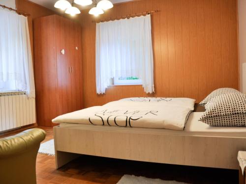 a bedroom with a bed and a chair in it at Apartments and rooms Nataša 1 in Trenta