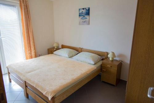 a bedroom with a bed with two pillows and a window at Apartments Beba in Vir