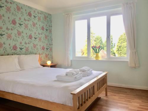 a bedroom with a bed with towels on it at Apple Perch 2BR Flat - Free Parking in Oxford