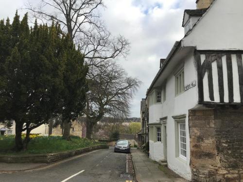 a car parked on a street next to a white building at Historic Grade II Listed Homely Cottage in Stamford