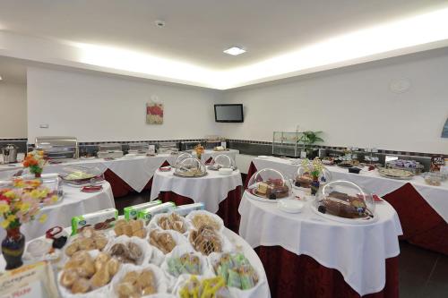 a room filled with tables with white tablecloths at Hotel Relax Roma Nord in Fiano Romano