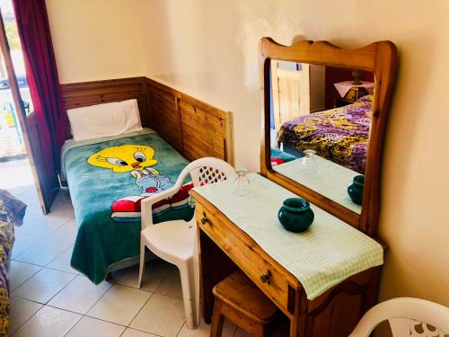 a bedroom with a mirror and a bed and a table at Le Lagon Bleu Oualidia in Oualidia