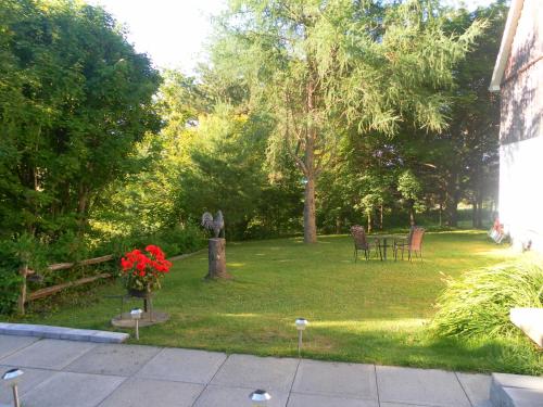 a garden with a table and chairs in the grass at Auberge de la Tour et Spa in Magog-Orford