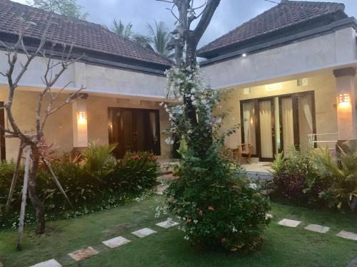a house with a christmas tree in front of it at Pondok Ardi Villas in Tejakula