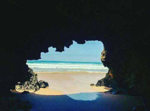 a cave on the beach with the ocean in the background at Le Lagon Bleu Oualidia in Oualidia