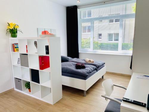 a room with a bed and a book shelf at Moderner Bungalow, 20 Minuten bis Hannover City, 24h Check-In in Garbsen