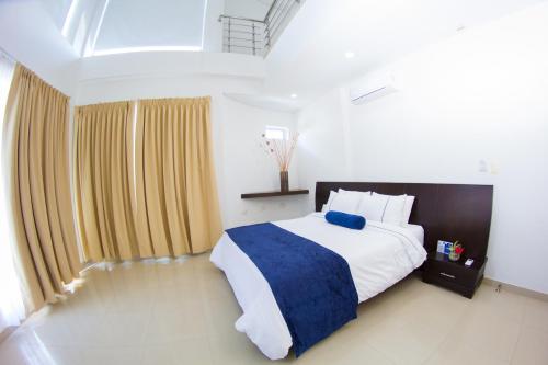 a bedroom with a large bed with blue and white sheets at Hotel Altamar Cartagena in Cartagena de Indias