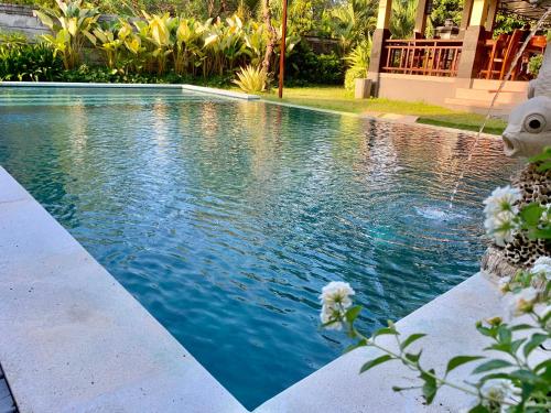 a swimming pool with blue water in a yard at Pondok Ardi Villas in Tejakula