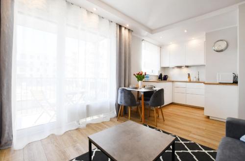 uma cozinha e uma sala de estar com mesa e cadeiras em Apartament Baltic Pearl em Colberga