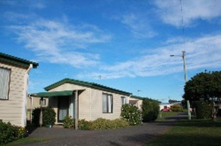 
a house that is in front of a building at Abel Tasman Cabins Devonport in Devonport
