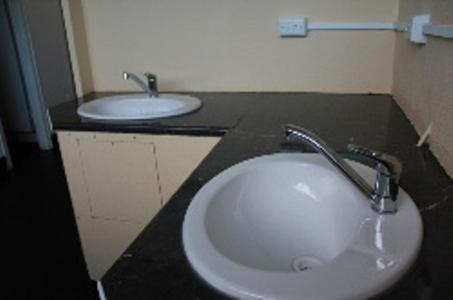 a bathroom with two sinks and a black counter at Abel Tasman Cabins Devonport in Devonport