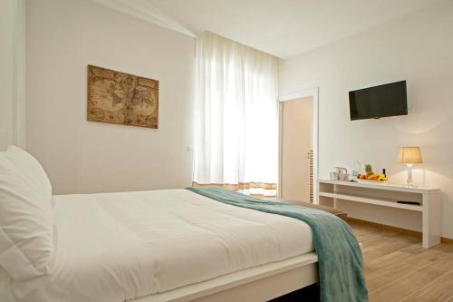 - une chambre blanche avec un lit et une télévision dans l'établissement Affittacamere My Home, à Livourne