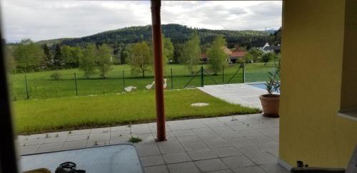 a view from a window of a yard with a field at Haus Falkenstein in Moosburg