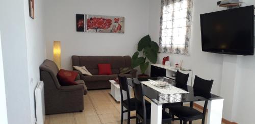 a living room with a couch and a table with chairs at Font Major in Horta de San Joan