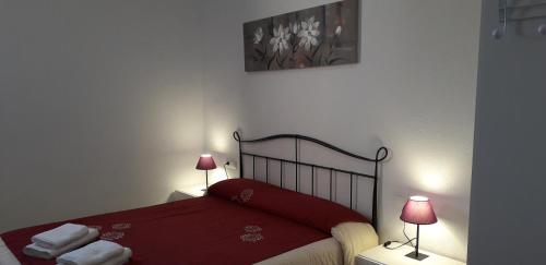 1 dormitorio con 1 cama roja y 2 lámparas en Font Major en Horta de Sant Joan