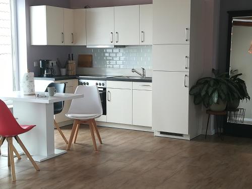 a kitchen with white cabinets and a table and chairs at Oleander Hof in Hochstadt