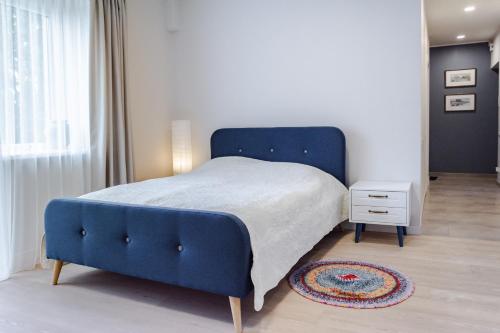 a blue bed in a bedroom with a blue chair at Near park apartment with balcony in Birštonas