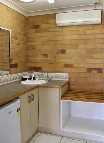 a kitchen with a sink and a mirror at Copper Country Motor Inn in Nanango