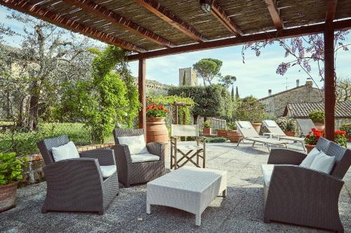 a patio area with chairs, tables and umbrellas at B&B Daria Monticchiello in Monticchiello
