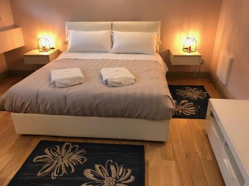 a bedroom with a large white bed with two lamps at Cantine De Gregorio Suites in Sciacca