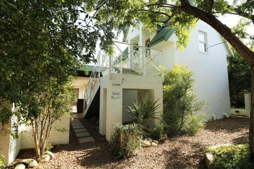 a white house with a staircase on the side of it at Eden Studios in Riebeek-Kasteel