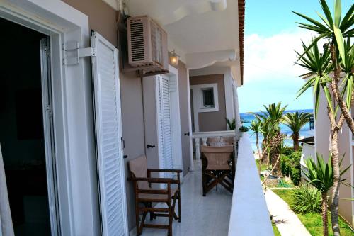 a balcony of a house with a table and chairs at Roula Kotsonis Superior Apartment in Argasi
