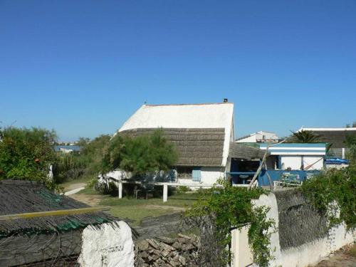 a house with a roof and a stone wall at Hôtel Le Neptune en Camargue in Saintes-Maries-de-la-Mer