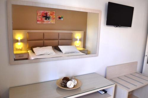a room with a bed with a mirror on the wall at Roula Kotsonis Superior Apartment in Argasi