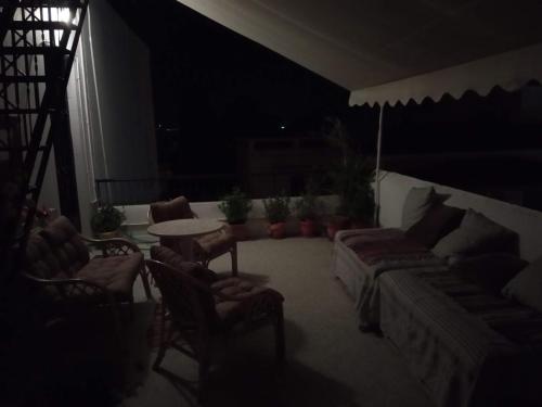 a living room with a couch and chairs and a table at Captain's Rooms in Aegina Town