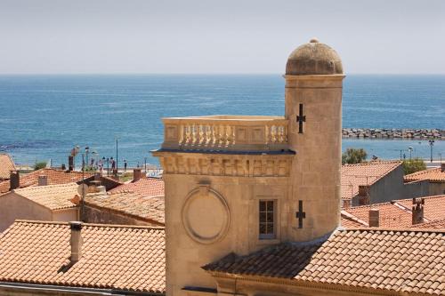 a building with a clock tower on top of roofs at Hôtel Le Neptune en Camargue in Saintes-Maries-de-la-Mer