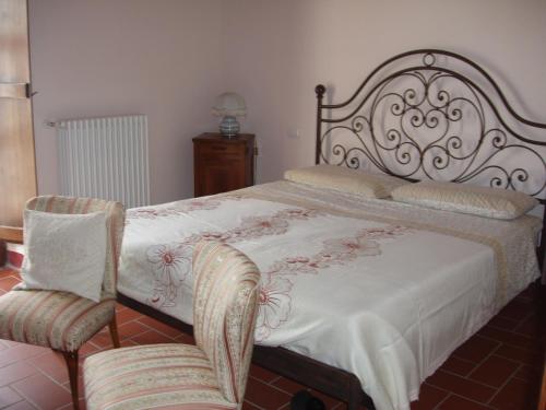 a bedroom with a bed and two chairs in it at Podere Erba appartamento con piscina in Cinigiano