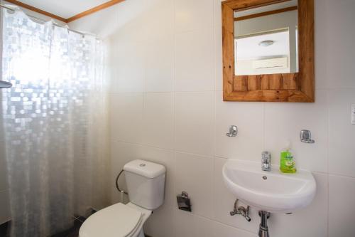 a bathroom with a toilet and a sink and a mirror at Tropical Breeze Curaçao in Santa Catharina