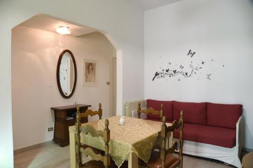 a living room with a red couch and a table at La Casa di Nonna Videlma in Carrara